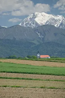 Images Dated 25th May 2004: SLOVENIA-GORENJSKA-Moste: Church & Field with Kamnik-Savinja Alps / Summer