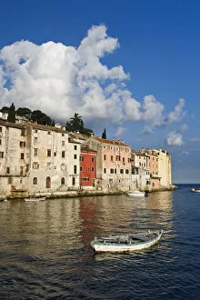 Small boat and buildings reflecting on the Adriatic Sea at sunrise, Rovigno, Croatia