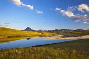 Augusta Prints: Small lake reflects Haystack Butte and the Rocky Mountain Front in Montana