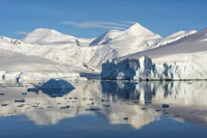 Antarctica Prints: Snow covered island and iceberg with reflection in South Atlantic Ocean, Antarctica