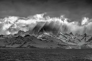 Images Dated 23rd January 2024: South Georgia Island. Opening in clouds and Virga reveal the mountainous and glaciated landscape