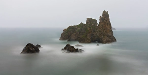 Sea Stack Prints: Spain. Ocean sea stack on misty coastline