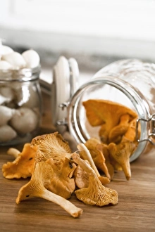Stockholm, Sweden - Closeup of dried mushrooms coming from a jar thats lying on a countertop Stockholm, Sweden - Closeup of dried mushrooms coming from a jar thats lying on a countertop