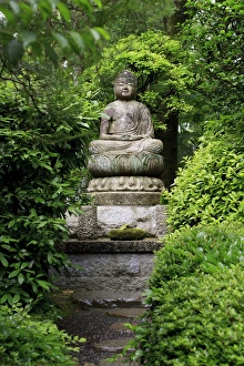 A stone Buddha statue in the grounds of Ryoan-Ji Temple in Kyoto, Japan