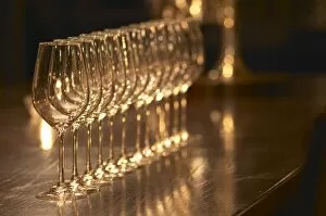 A straight row of wine tasting glasses lilned up on a dark wooden table. Ulriksdal