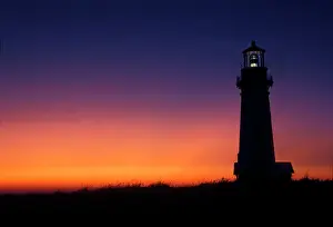Newport Prints: The sun ball drops down on the colorful horizon Yaquina Bay lighthouse on the coast