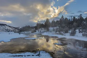 Sunrise clouds reflect into Grassy Spring in winter in Yellowstone National Park Sunrise clouds reflect into Grassy Spring in winter in Yellowstone National Park