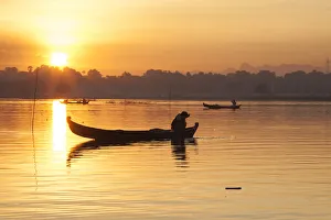 Images Dated 11th January 2018: Sunrise over the lake with fishermen on boats fishing in the lake near wooden footbridge