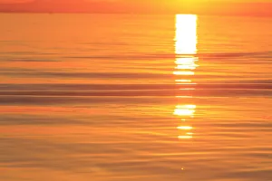 Sunset colors and patterns on small waves in water