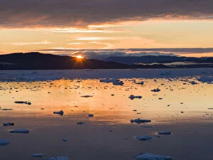 Sunset over fjord with icebergs close to Eqip Glacier in Greenland, Danish Territory