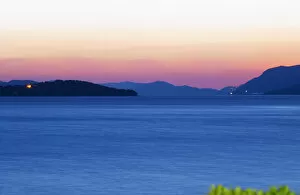 Sunset over the sea. View over the islands Daksa and others. House lights. Dark blue sea