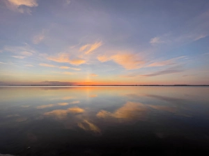 Sunset sky reflected on tranquil water on beach