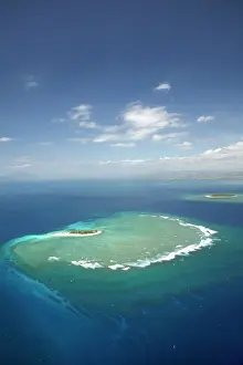 Turquoise Prints: Surf on reef off Namotu Island, and Tavarua Island in distance, Mamanuca Islands