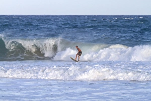 Surfing Prints: Surfer riding pacific ocean waves off the island coast of Kauai, Hawaii, USA