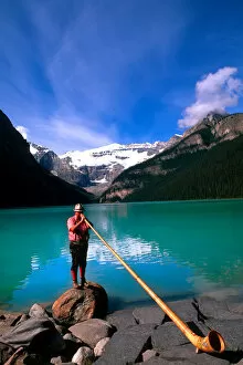 Swiss Alphorn player at Lake Louise in Banff Canada