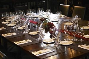 Table set for lunch guests with many wine glasses for tasting and knives and forks
