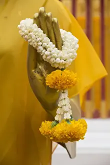 Thailand, Chiang Mai Province, Wat Phra That Doi Suthep. Buddha statue hand close-up with marigold