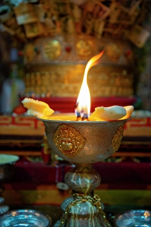Images Dated 25th June 2024: Tibet, Kham, Litang. A candle burns at the altar of a Litang Monastery