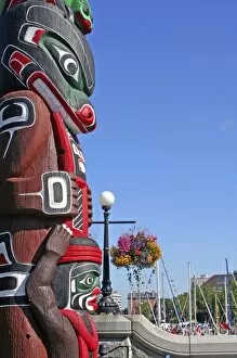 Totem hanging floral baskets along waterfront Victoria British Columbia