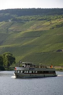 Tour boat on the Mosel River in northwest Germany with vineyards on the hillside