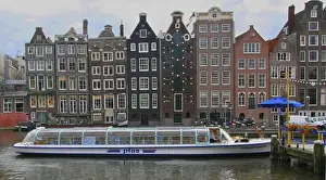 Images Dated 7th September 2007: A tour boat waiting at Rederij Plas dock on a canal lined with colorful gabled homes