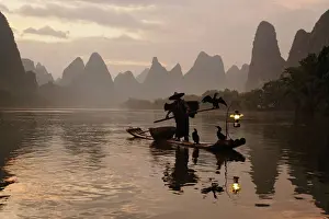 Editor's Picks: Traditional Chinese fisherman with cormorants on Li River at sunrise, near Guilin, China