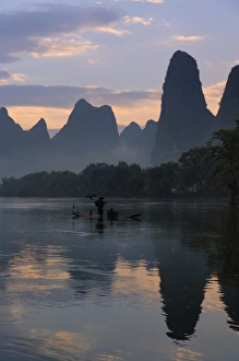 Guilin Prints: Traditional fisherman with his cormorants on the Li River at sunrise, Guilin, China