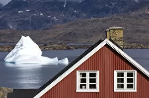 Traditional house and iceberg Tasiilaq (Ammassalik) Greenland