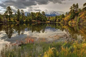 A tranquil pond reflects Mt. Snaffles and Fall in the Colorado Rocky Mountains