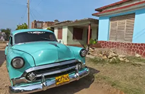 Images Dated 2029: Trinidad Cuba with blue classic 1950s Chevrolet auto on cobbled streets in colorful