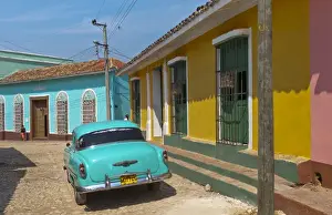 Images Dated 2029: Trinidad Cuba with blue classic 1950s Chevrolet auto on cobbled streets in colorful