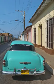 Images Dated 2029: Trinidad Cuba with blue classic 1950s Chevrolet auto on cobbled streets in colorful