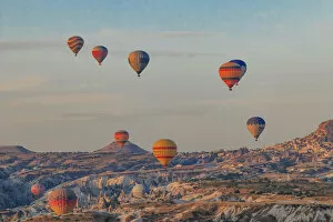 Turkey Gallery: Turkey, Anatolia, Cappadocia, Goreme. Hot air balloons flying above / among rock formations