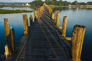Images Dated 21st March 2015: U Bein teak bridge on Taungthaman Lake at sunrise, Citadel Pagoda in the distance