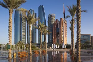 UAE, Abu Dhabi, Etihad Towers and Emirates Palace Hotel fountains, dusk