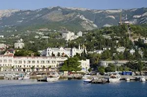 Ukraine, Yalta. Black Sea view of the port of Yalta with the Crimean Mountains in