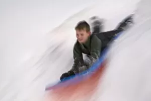 Images Dated 22nd December 2007: United States, Washington, Crystal Mountain, boy on sled in motion (MR)