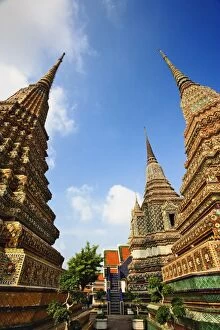 Upward view of chedis including distant Phra Si Sanphet Chedi, Wat Pho, Bangkok, Thailand
