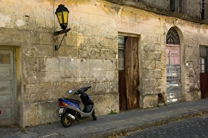 Uruguay. Colonia del Sacramento. Barrio Historico. Scooter outside an abandoned building