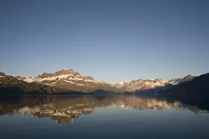 Images Dated 14th August 2007: USA, Alaska, Glacier Bay National Park, Sunrise on mountains reflected in still water