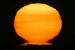 Images Dated 11th February 2005: USA, Alaska, Homer. Sun at sunset distorts to look like a nuclear fireball. Credit as