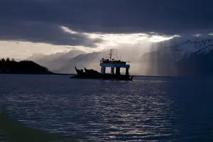 USA, Alaska, Icy Bay. Fishing boat returning home in evening light