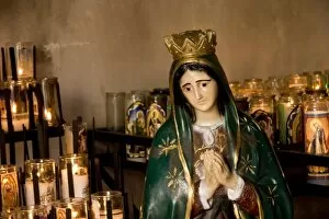 USA, Arizona, Tucson. Close-up of burning votive candles and Our Lady of Guadalupe