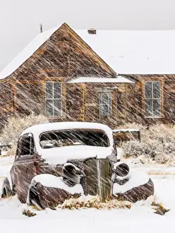 Snowing Prints: USA, California, Bodie. Abandoned car and building in snowfall