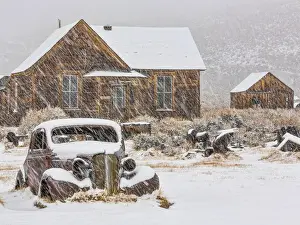 Snowing Prints: USA, California, Bodie. Abandoned car and buildings in snowfall