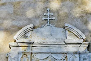 USA, California, Carmel. Inside the grounds at the Carmel Mission Basilica Museum cross against wall