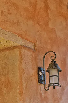Stucco Prints: USA, California, Carmel. Inside the grounds at the Carmel Mission Basilica Museum old iron lamp on stucco wall