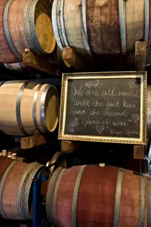 Chalk Board Prints: USA, California, Napa Valley. An Eduardo Galeano quote on a chalkboard among wooden barrels of wine