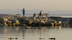 Protection Prints: USA, California, Salton Sea. Men fishing at sunset in Salton Sea
