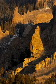 Images Dated 17th January 2022: USA, Colorado, Gunnison National Forest. Sunrise on cliffs and forest in autumn